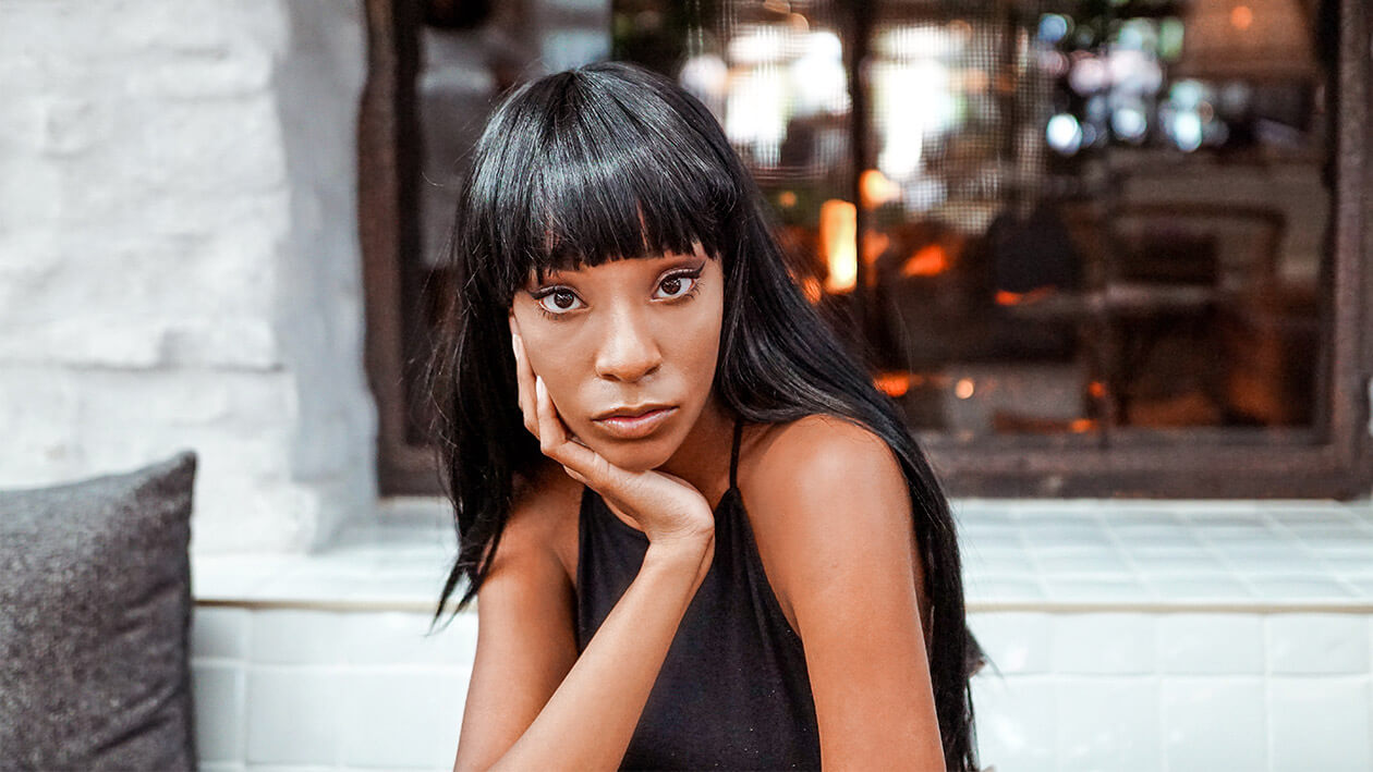 A girl wearing black dress looking at the camera