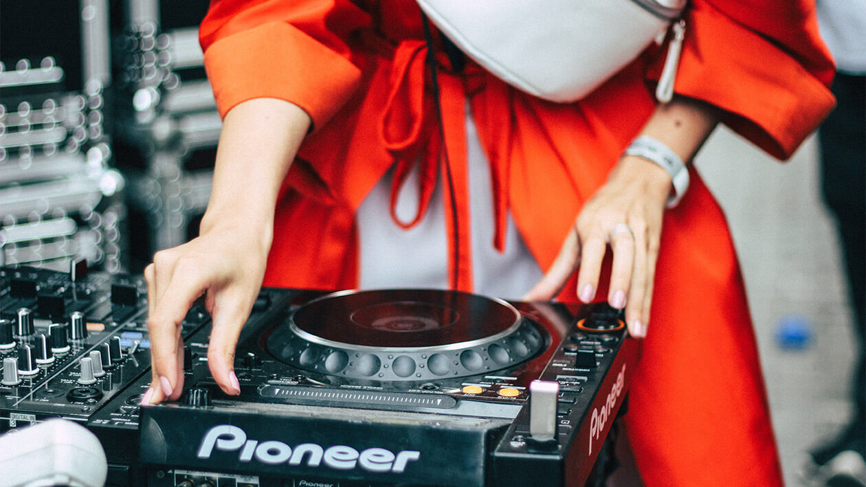 A person playing DJ on a pioneer machine