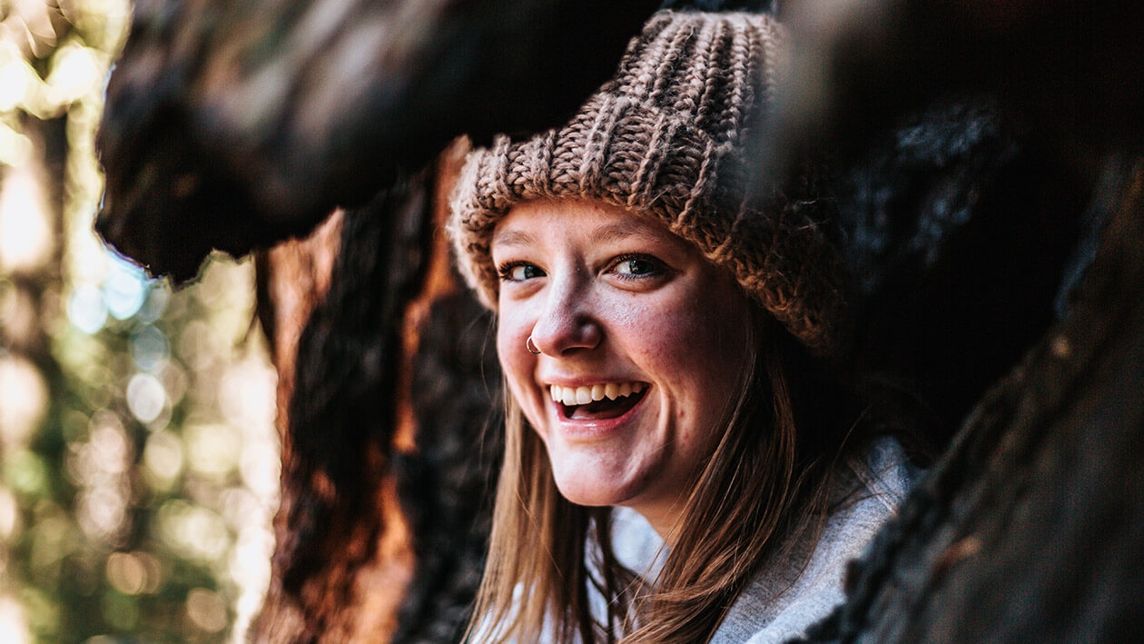 Close up shot of a lady wearing cap, smiling at the camera