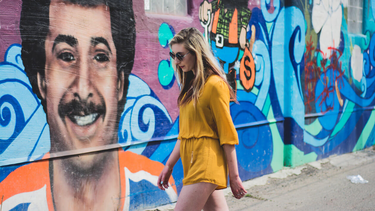 A girl wearing yellow dress walking on the street