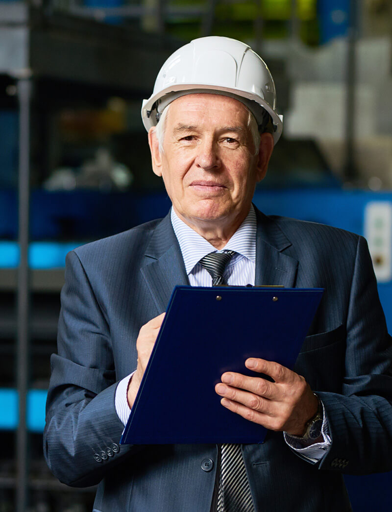 An old man with a construction hat working at a site